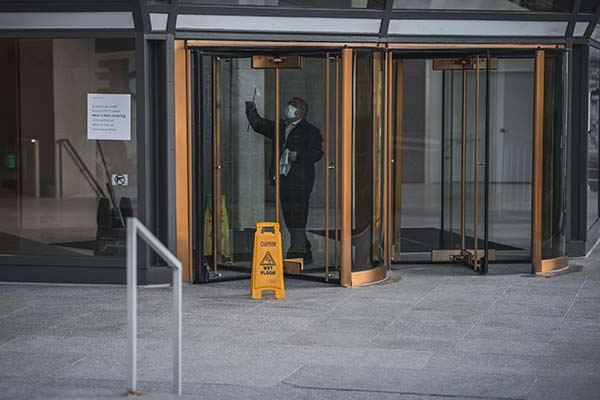man cleaning the inside of an office revolving door